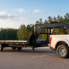 Black 8.5x32 deckover gooseneck trailer hitched to a one-ton dually pickup — gooseneck trailers for sale at PrimeLoad
