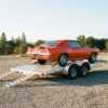 Steel-deck open car hauler trailer with a classic muscle car loaded — open car trailers for sale at PrimeLoad