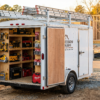 White 7x14 enclosed contractor trailer at a residential jobsite with ladder rack — contractor trailers for sale at PrimeLoad