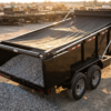 Black 7x14 tandem-axle dump trailer with electric roll-tarp system extended over gravel load — dump trailer tarp kit at PrimeLoad