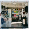 Interior of a white enclosed cargo trailer outfitted as a mobile detail business with pressure washer, tanks, and storage — mobile detail trailer setup at PrimeLoad