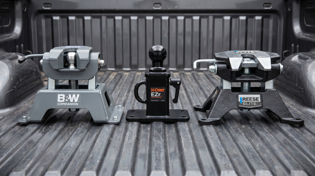Three gooseneck hitch ball assemblies side-by-side: B&W Companion, Curt EZr, Reese ELITE in a pickup bed — gooseneck hitch comparison at PrimeLoad
