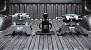 Three gooseneck hitch ball assemblies side-by-side: B&W Companion, Curt EZr, Reese ELITE in a pickup bed — gooseneck hitch comparison at PrimeLoad
