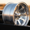 Polished aluminum trailer wheel with chrome highlights and water beading on the surface — aluminum trailer wheel care at PrimeLoad