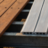 Side-by-side comparison of brown Apitong tropical hardwood deck planks and ribbed aluminum extruded deck planks — apitong vs aluminum deck at PrimeLoad