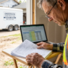 Contractor reviewing tax depreciation schedules with a contractor trailer in the background — best tax strategies for contractor trailers at PrimeLoad